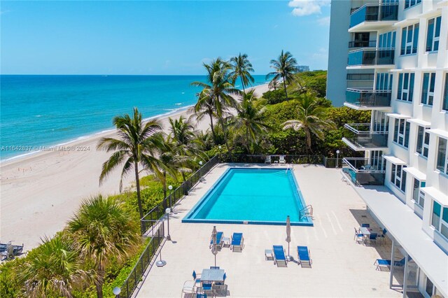 view of swimming pool featuring a view of the beach and a water view