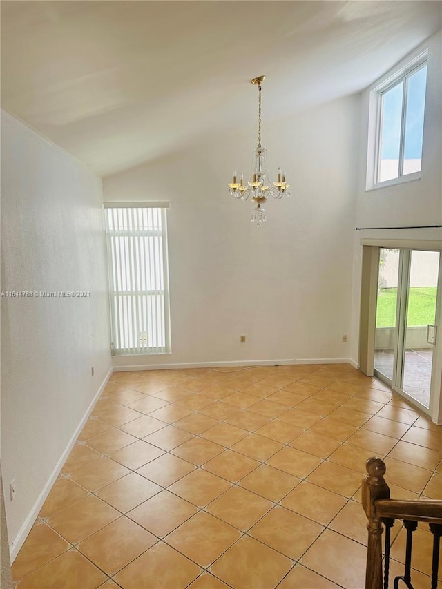 spare room with vaulted ceiling, a chandelier, and light tile patterned flooring