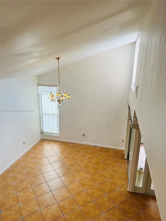 empty room with high vaulted ceiling, a chandelier, and tile patterned floors