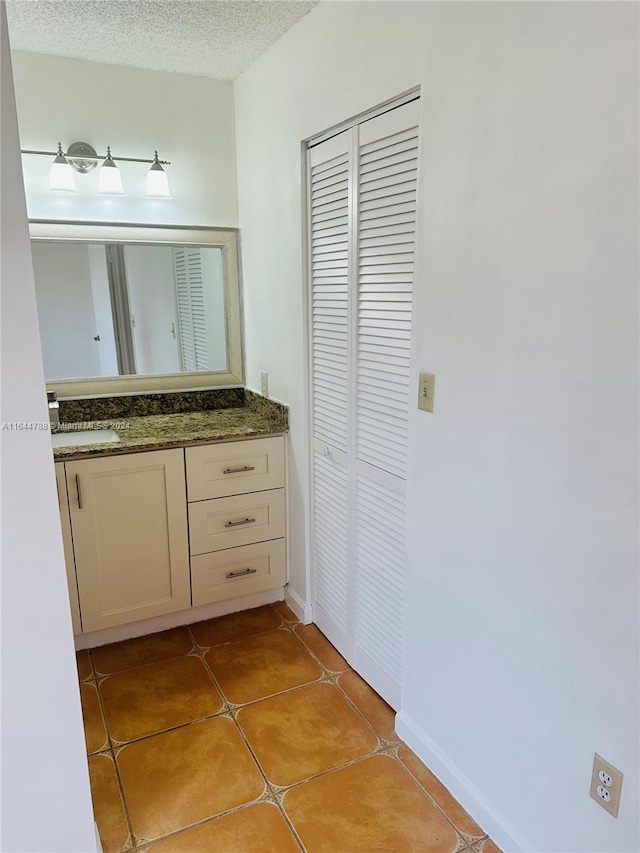 bathroom featuring vanity, a textured ceiling, and tile patterned floors