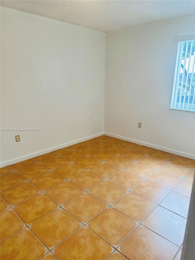 unfurnished room with tile patterned flooring and a textured ceiling