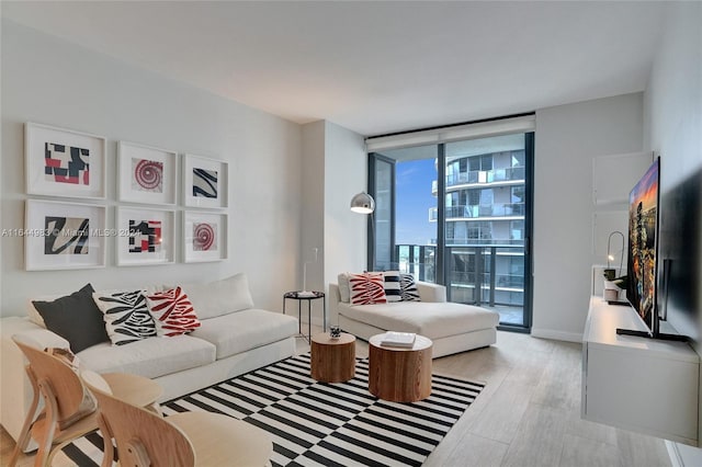 living area featuring expansive windows, baseboards, and wood finished floors