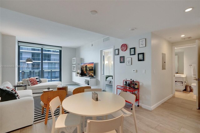 dining area with light hardwood / wood-style flooring and electric panel