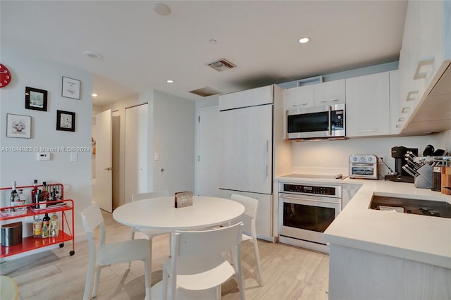 kitchen featuring white cabinets, light hardwood / wood-style flooring, and stainless steel appliances