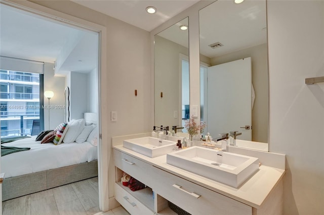 bathroom with dual vanity and hardwood / wood-style flooring