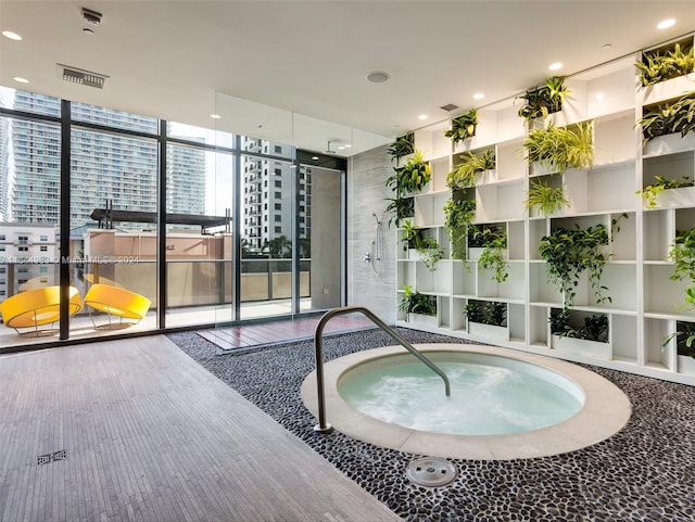 view of swimming pool with a view of city and an indoor in ground hot tub