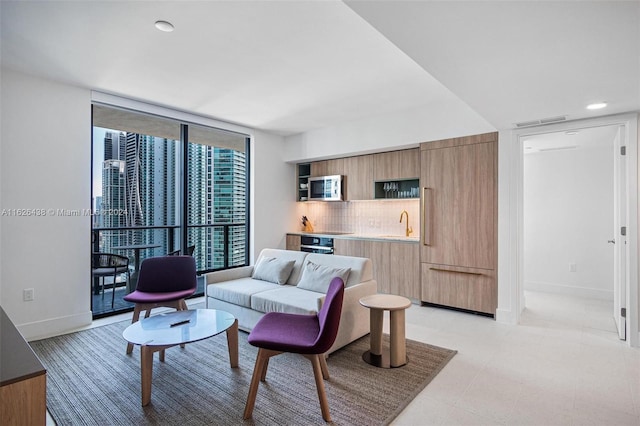 living room featuring floor to ceiling windows and sink