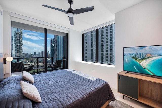 tiled bedroom with ceiling fan and expansive windows