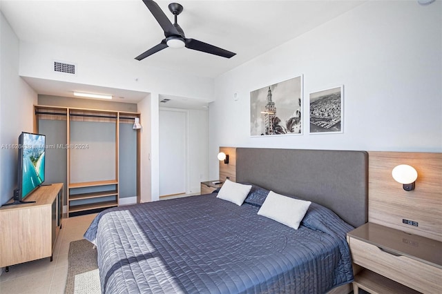 tiled bedroom with ceiling fan and a closet