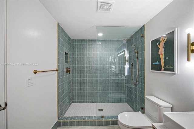 bathroom with toilet and tiled shower