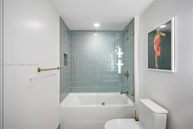 bathroom featuring tiled shower / bath combo and toilet