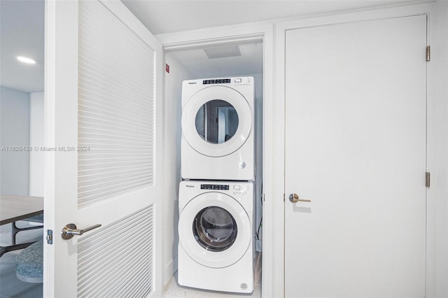 laundry area featuring tile patterned floors and stacked washing maching and dryer