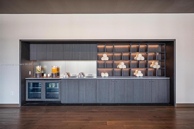 bar with dark hardwood / wood-style flooring and wine cooler