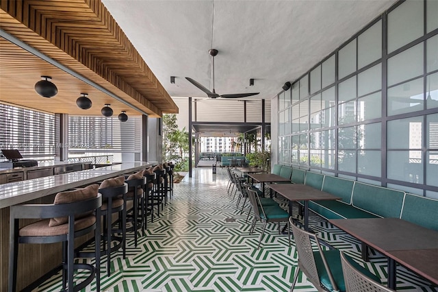 dining area with floor to ceiling windows and ceiling fan