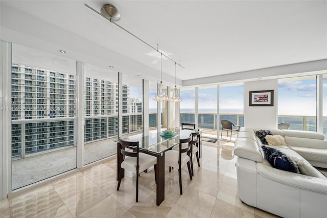 dining area featuring expansive windows, a water view, and light tile patterned flooring