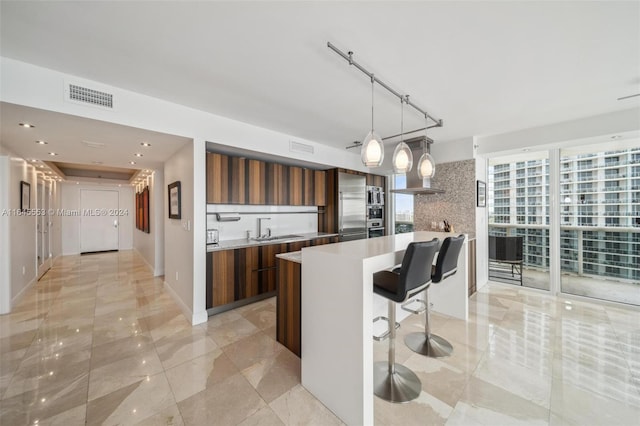 kitchen featuring a sink, visible vents, light countertops, stainless steel built in fridge, and modern cabinets