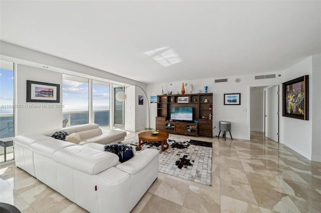 living area with expansive windows, visible vents, and baseboards