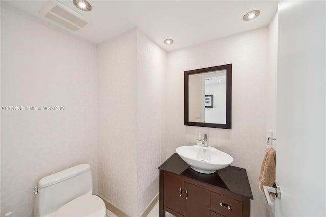 half bathroom featuring toilet, recessed lighting, visible vents, and vanity