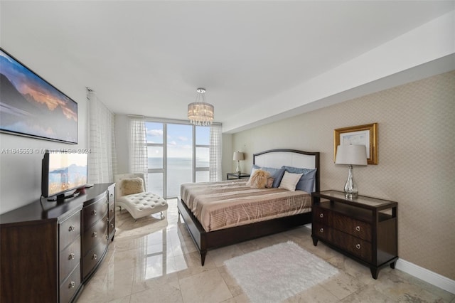 bedroom with wallpapered walls, baseboards, floor to ceiling windows, and a notable chandelier