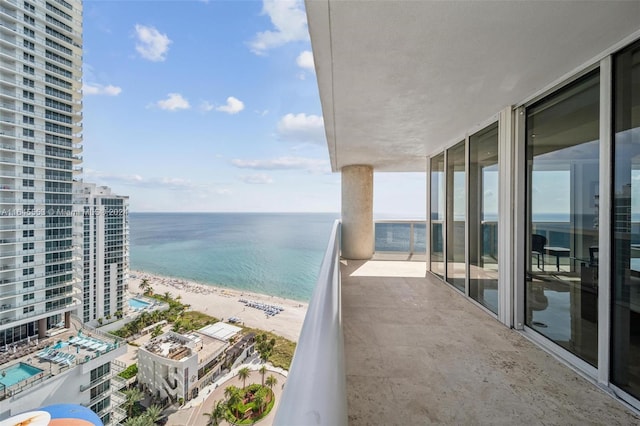 balcony featuring a view of the beach and a water view