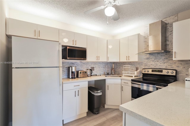 kitchen with wall chimney exhaust hood, tasteful backsplash, stainless steel appliances, sink, and ceiling fan