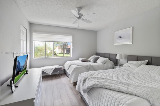 bedroom featuring a textured ceiling, wood-type flooring, and ceiling fan