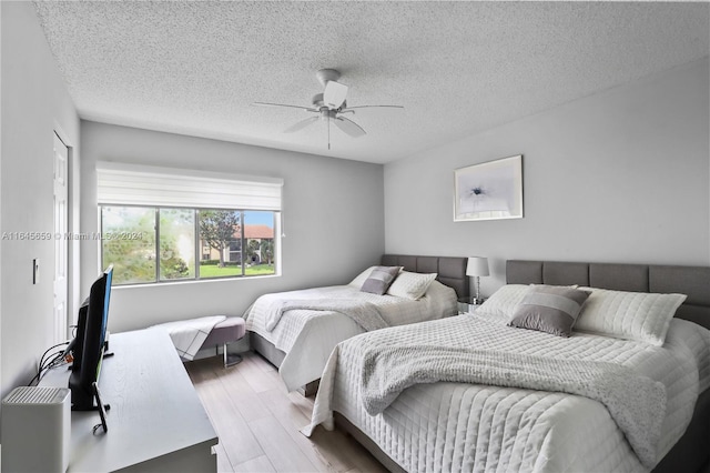 bedroom featuring a textured ceiling, ceiling fan, and hardwood / wood-style flooring