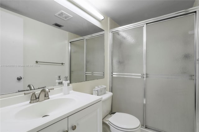 bathroom with vanity, toilet, and walk in shower