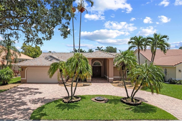 mediterranean / spanish house featuring a front yard and a garage