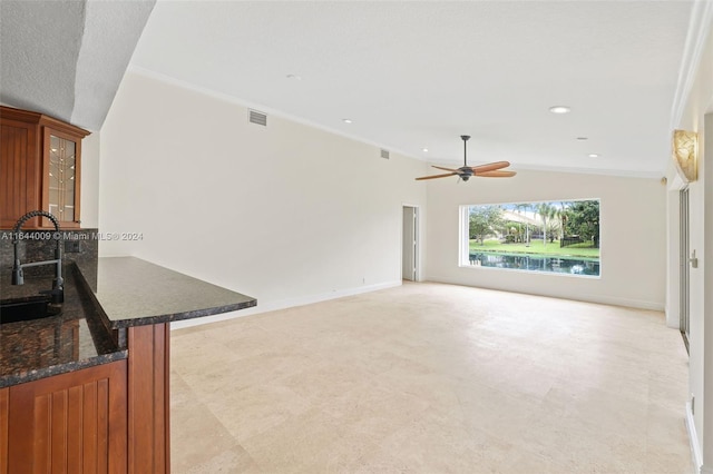 living room with ceiling fan, lofted ceiling, sink, a textured ceiling, and crown molding