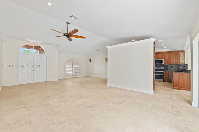 unfurnished living room featuring ceiling fan, lofted ceiling, and sink