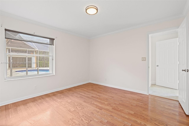 empty room with ornamental molding and light hardwood / wood-style floors