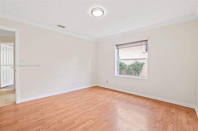 unfurnished room featuring light wood-type flooring and crown molding