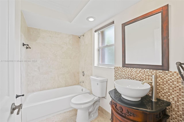 full bathroom with tile walls, backsplash, vanity, tiled shower / bath combo, and toilet