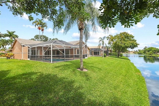 view of yard with glass enclosure and a water view