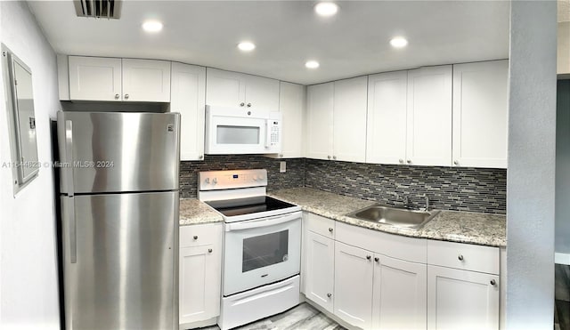 kitchen with sink, white appliances, and white cabinets