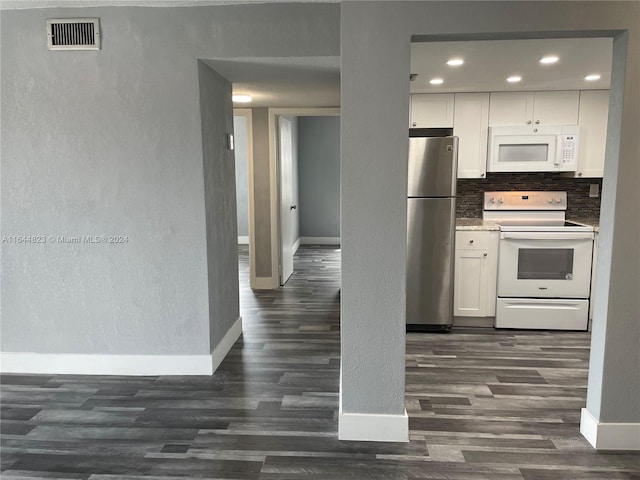 kitchen with dark wood-type flooring, white appliances, decorative backsplash, and white cabinetry