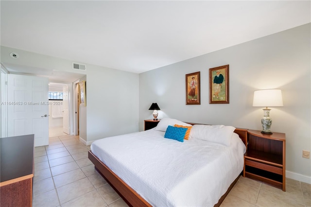 bedroom featuring light tile patterned flooring and connected bathroom