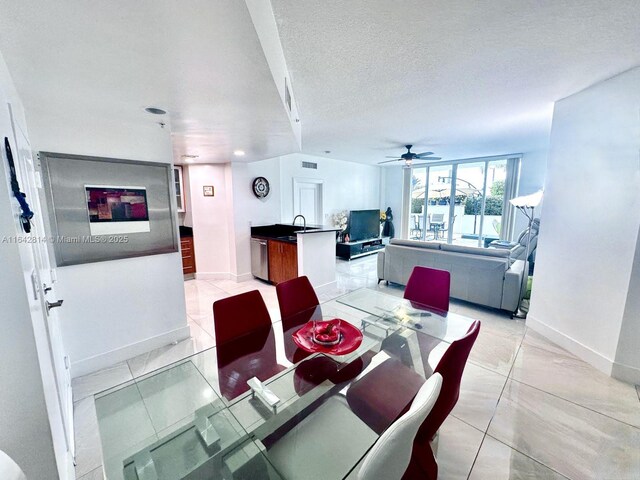 dining area featuring ceiling fan, sink, a textured ceiling, and light tile patterned floors