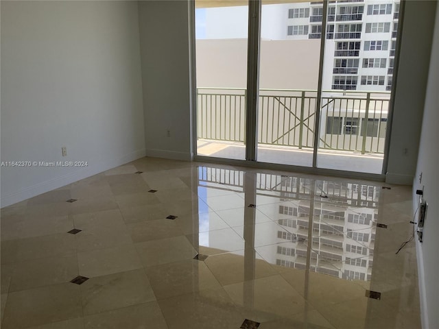 tiled empty room featuring a healthy amount of sunlight