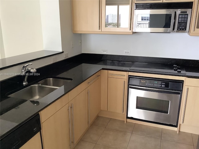 kitchen with sink, stainless steel appliances, light brown cabinets, and tile patterned floors