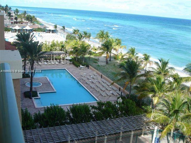 view of swimming pool featuring a patio and a water view