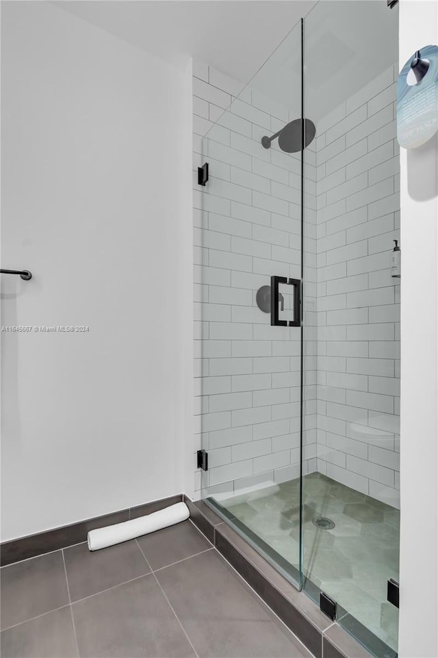 bathroom with a shower with shower door and tile patterned floors