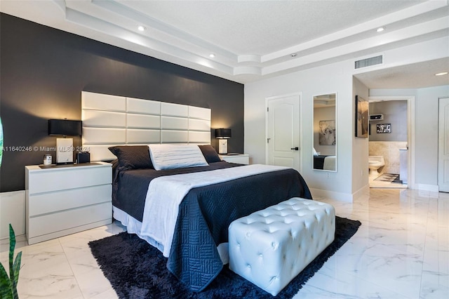 bedroom featuring ensuite bathroom, a tray ceiling, and light tile patterned flooring