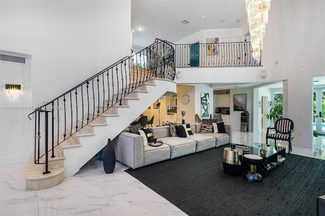 living room featuring a towering ceiling, tile patterned floors, and a chandelier