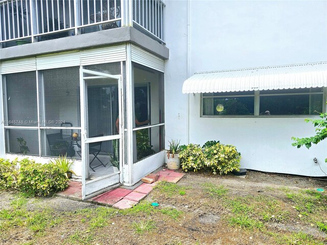 view of property exterior with a balcony and a sunroom