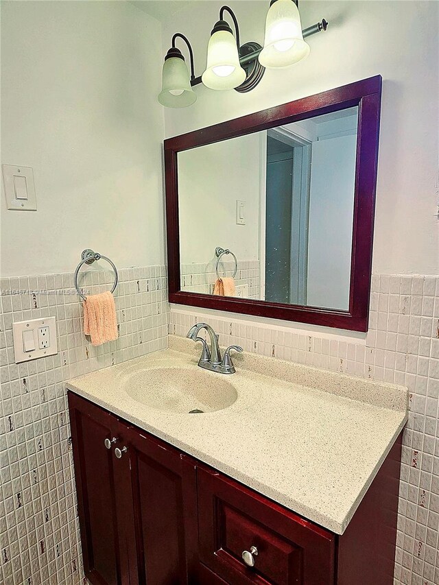 bathroom featuring tasteful backsplash, vanity, and tile walls