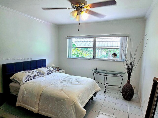 tiled bedroom with ceiling fan and ornamental molding