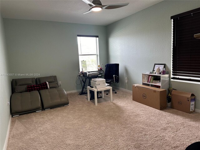 home office featuring light carpet and ceiling fan