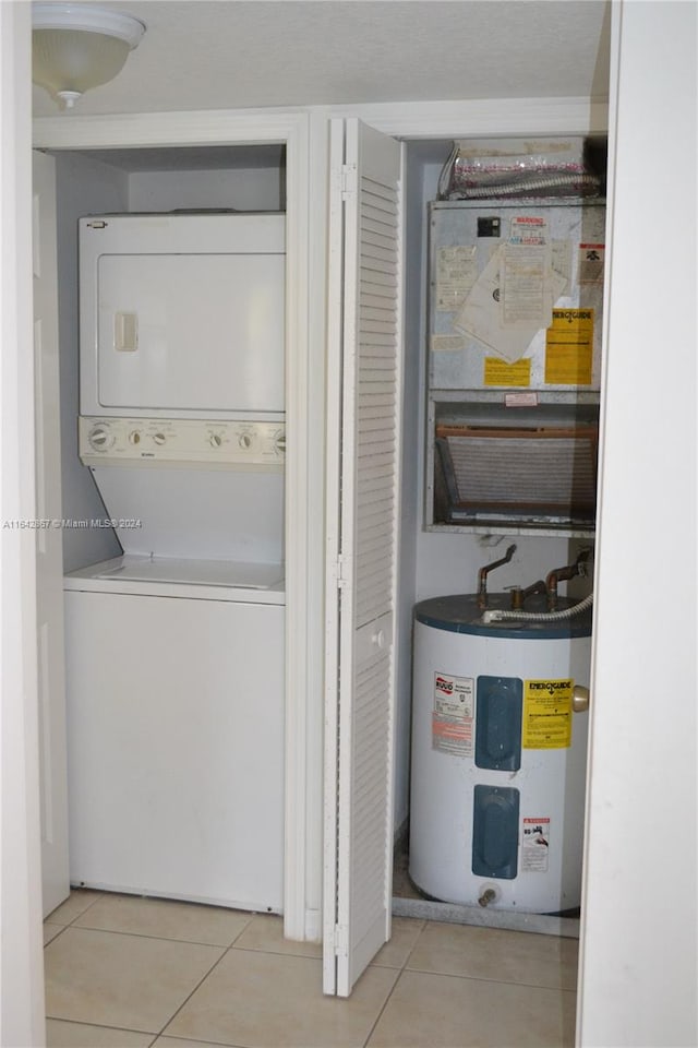 utility room featuring stacked washer / dryer and water heater